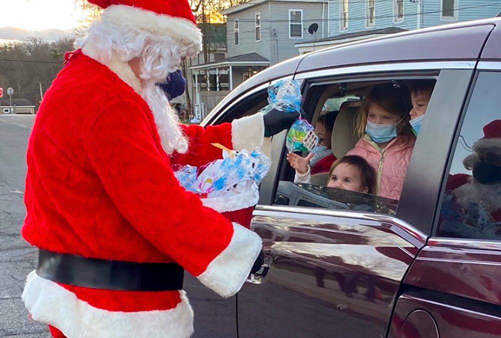 Santa Claus hands out treat bags to children at Sunday’s drive-thru Christmas event in Shawangunk.